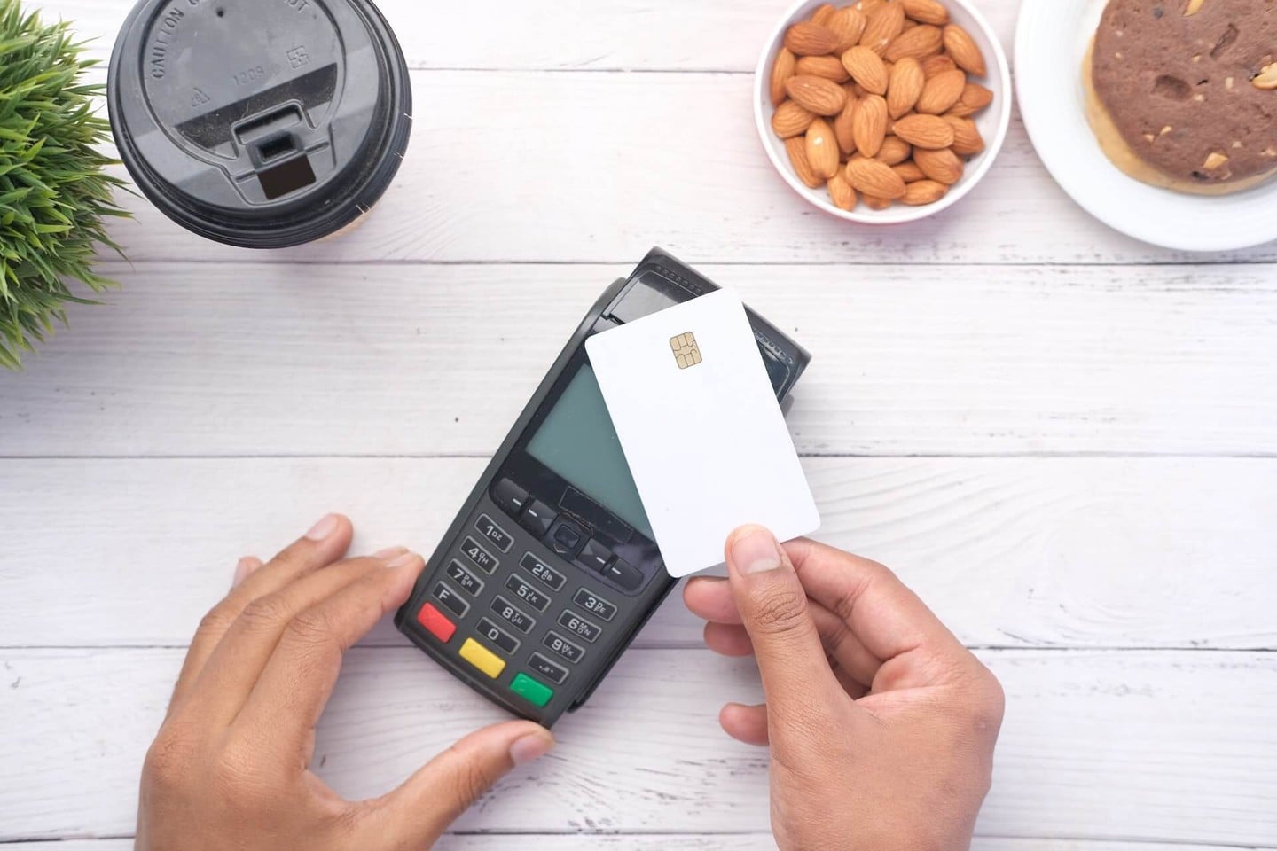 Person holding credit card against card reader Person holding credit card against card reader