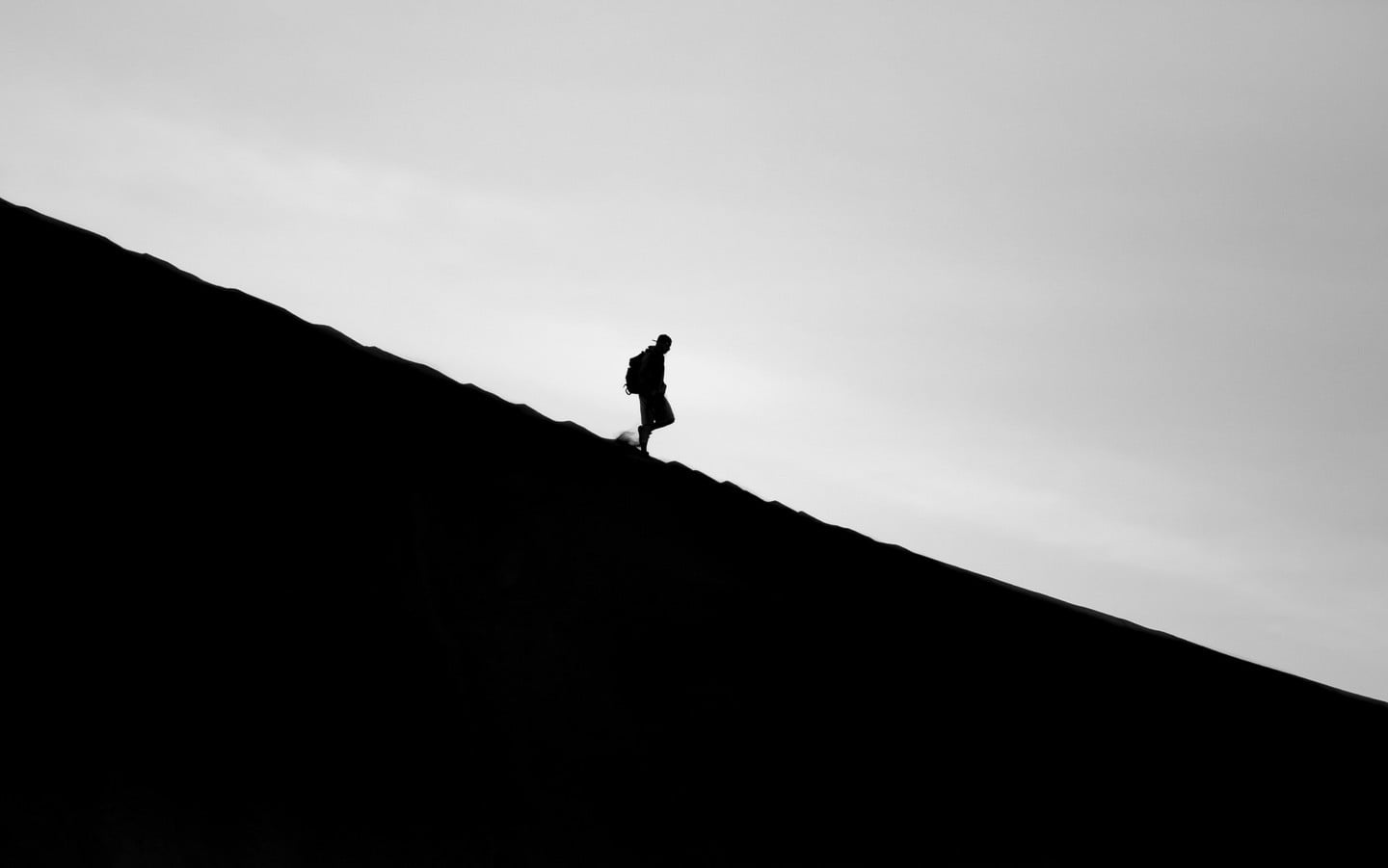 Silhouette of a man walking downhill Silhouette of a man walking downhill