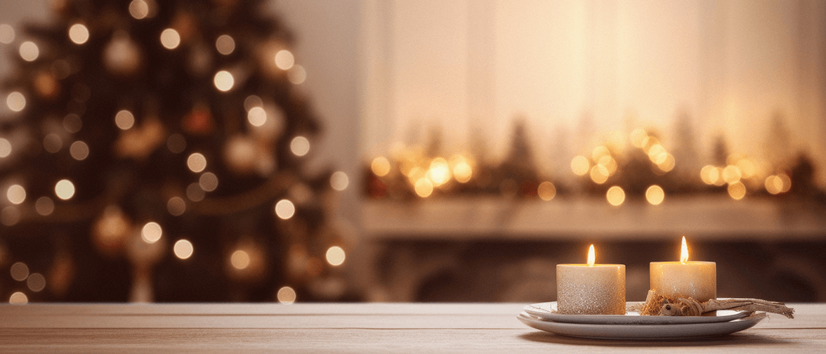 Two candles on a table in front of a Christmas scene Two candles on a table in front of a Christmas scene